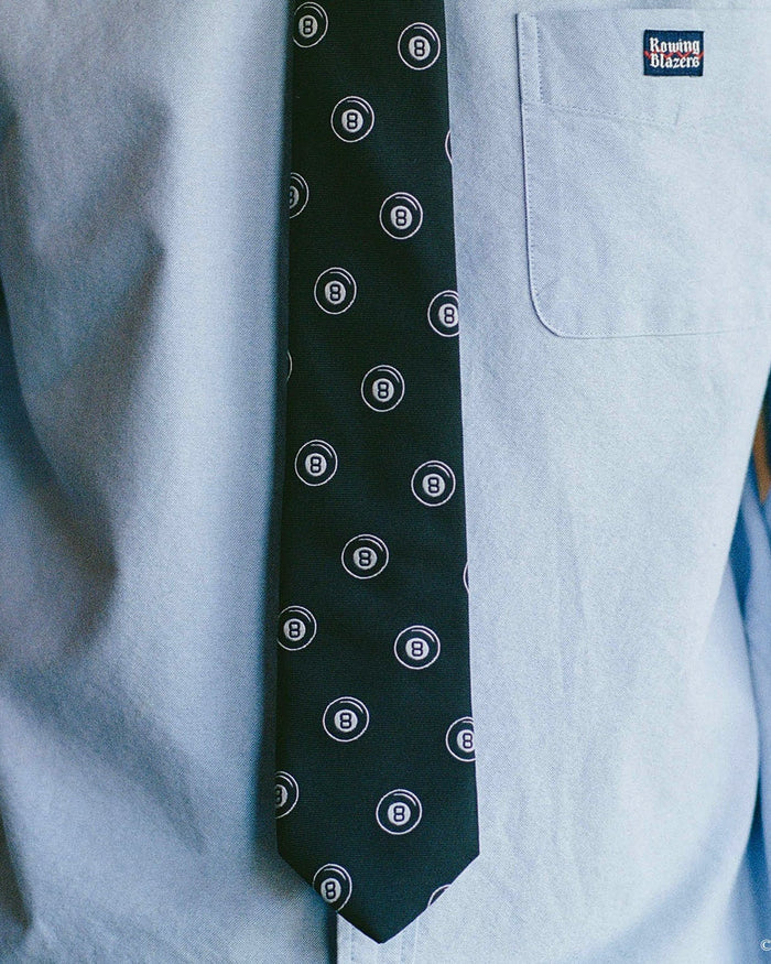 Black tie with magic 8 ball pattern on a light blue shirt